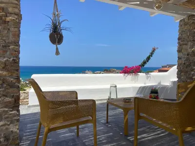 a patio with chairs and a table and the beach at Addauro in Alcamo