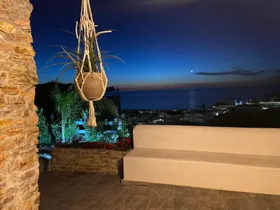 a view of the city at night with a bench at Addauro in Alcamo