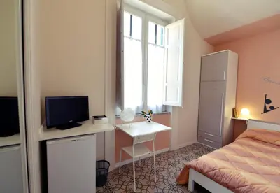a bedroom with a bed and a desk with a television at *1*7*4* Via Roma in Palermo