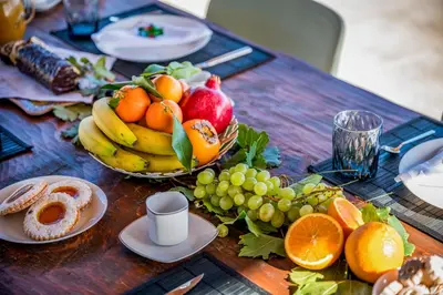a wooden table with a bowl of fruit on it at Villa Pharus Scopello in Scopello