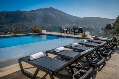 a row of chaise lounges sitting next to a swimming pool at Villa Pharus Scopello in Scopello