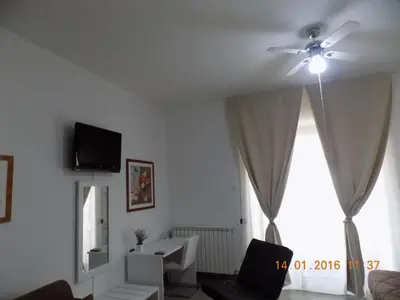 a living room with a ceiling fan and a window at B&B Porta delle Madonie in Campofelice di Roccella