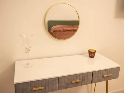 a mirror on a wall above a white table with a glass at La Premiere Suite - Teatro Massimo Palermo in Palermo