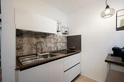 a kitchen with white cabinets and a sink at La Premiere Suite - Teatro Massimo Palermo in Palermo