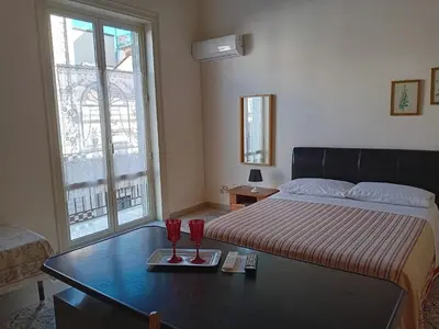 a bedroom with a bed with two red glasses on a table at Casa nonno Enrico in via Oreto in Palermo