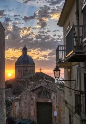 a view of a church with a sunset in the background at La Cupola - casa vacanze n 8 in Termini Imerese
