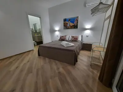 a bedroom with a bed and a wooden floor at b&b Lastracu in Castellammare del Golfo