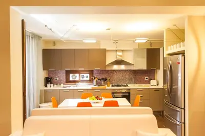 a kitchen with a table and orange chairs in it at Villa Lidia in Balestrate