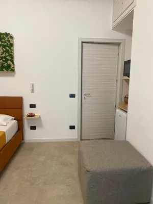 a bedroom with a bed and a door with a ottoman at Fiori di Quercia in Carini