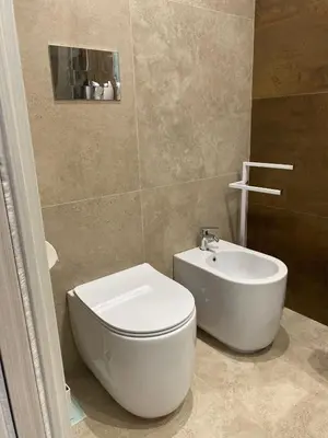a bathroom with a white toilet and a sink at Fiori di Quercia in Carini