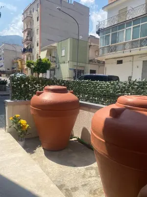 three large clay pots sitting on the side of a street at Fiori di Quercia in Carini