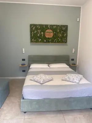 a bedroom with a bed with a painting on the wall at Fiori di Quercia in Carini