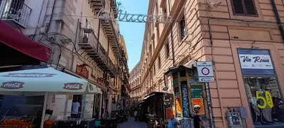 an alley with buildings and an umbrella on a street at Casa Vacanza Edy in Palermo