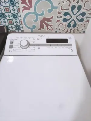 a white washing machine sitting in a room with a pillow at La casa sotto il castello in Caccamo
