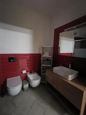 a bathroom with a sink and a toilet and a mirror at La casa sotto il castello in Caccamo