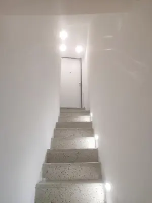 a stairway with a white door and a white wall at La casa sotto il castello in Caccamo