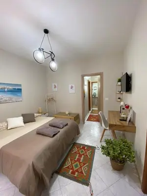 a bedroom with a large bed and a desk at La casa di Angela in Monreale
