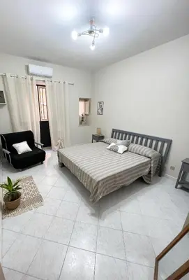 a bedroom with a bed and a chair in it at La casa di Angela in Monreale