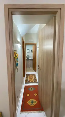 a hallway with an open door with a rug at La casa di Angela in Monreale