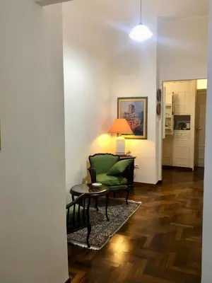 a living room with a green couch and a table at G&G ROOMS in Palermo