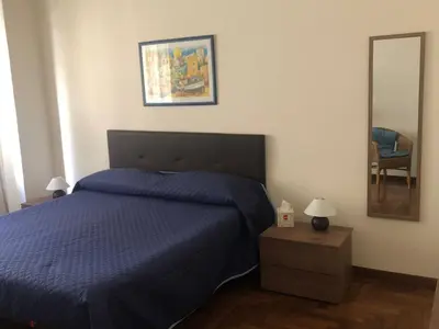 a bedroom with a blue bed and a mirror at G&G ROOMS in Palermo