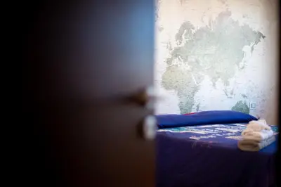 a bedroom with a blue bed with a map on the wall at Casamu' Management Apartment Palermo in Palermo