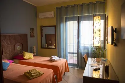 a hotel room with two beds and a window at Dolce Conca D'Oro B&B in Palermo