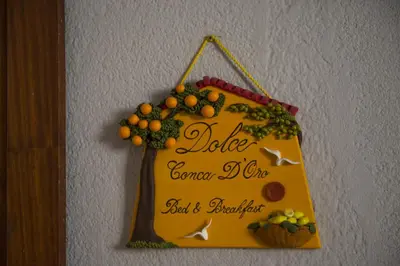 a sign hanging on a wall with fruit on it at Dolce Conca D'Oro B&B in Palermo