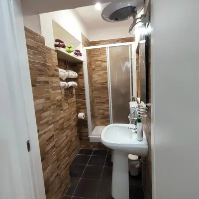 a bathroom with a white sink and a shower at La Casetta di Angy in Palermo