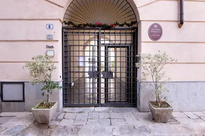 a door to a building with two potted trees in front at Viola's Luxury House in Palermo