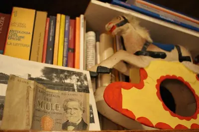 a book shelf filled with books and a stuffed animal at La Via delle Biciclette in Palermo