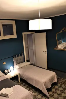 a bedroom with two beds and a chandelier at La Via delle Biciclette in Palermo