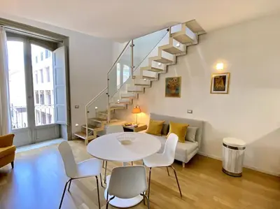 a living room with a table and a staircase at The Unique Loft Maqueda - in the city centre in Palermo