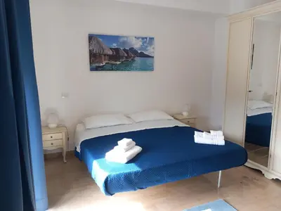 a bedroom with a blue bed with towels on it at Domus Oreto in Palermo