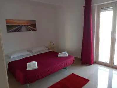 a bedroom with a bed with red sheets and a window at Domus Oreto in Palermo