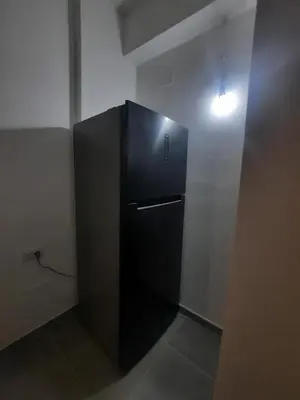 a black refrigerator in a room with a light at Domus Oreto in Palermo