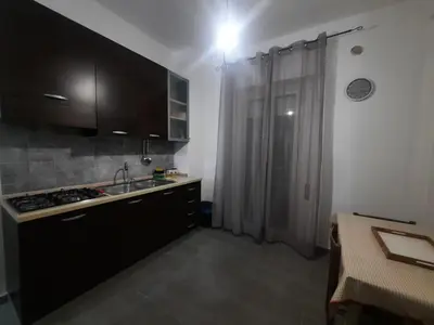 a kitchen with black cabinets and a sink and a shower at Domus Oreto in Palermo