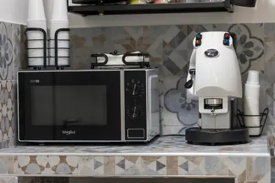 a white appliance sitting on a counter next to a microwave at Arco di Bonello Cattedrale in Palermo