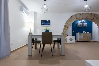 a dining room with a table and chairs and an archway at Arco di Bonello Cattedrale in Palermo