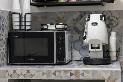 a white appliance sitting on a counter next to a microwave at Arco di Bonello Cattedrale in Palermo