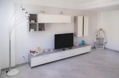 a living room with a tv on a white wall at Nelly Casa Vacanze in Porticello
