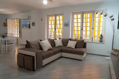 a living room with a brown couch in a living room at Nelly Casa Vacanze in Porticello