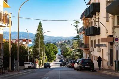 a city street with cars parked on the road at Nelly Casa Vacanze in Porticello
