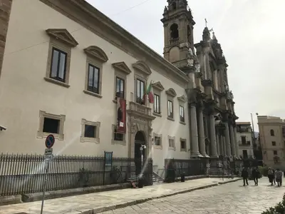 a large white building with a clock tower on a street at La Cupola in Palermo
