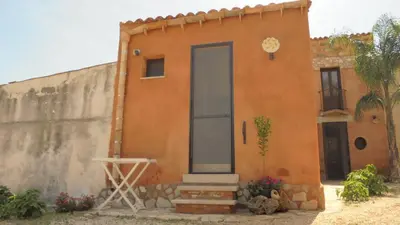 a house with a door on the side of it at Baglio Poma in Castelluzzo