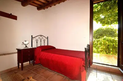 a bedroom with a red bed and a large window at Baglio Poma in Castelluzzo