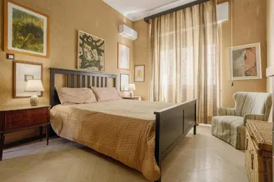 a bedroom with a large bed and a chair at Artist penthouse 2 in Palermo