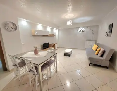 a living room with a table and a couch at Vespucci Holiday in Casteldaccia