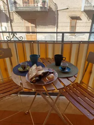 a table with a plate of food on a balcony at Vespucci Holiday in Casteldaccia