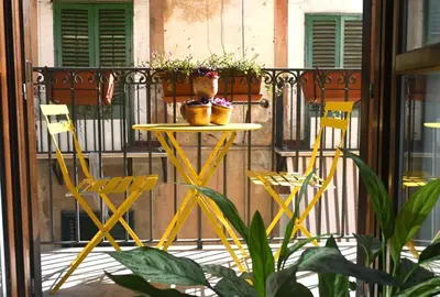 a table with two chairs and two plants on a balcony at Casamartú Apartment in Palermo